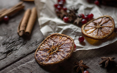 Table with orange slices, cinnamon stick and berries on