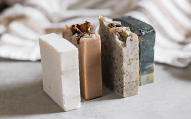 Four soap bars with different patterns on them. A blanket is in the background.