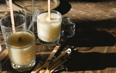 Two made candles one without the wick cut yet with some candle making stuff around them
