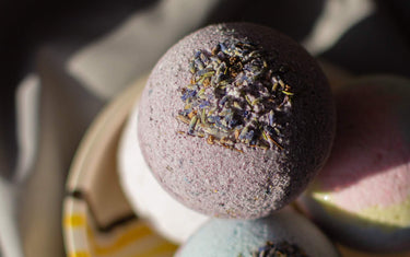 Close up of a purple bath bomb with lavender sprinkled into the top of it