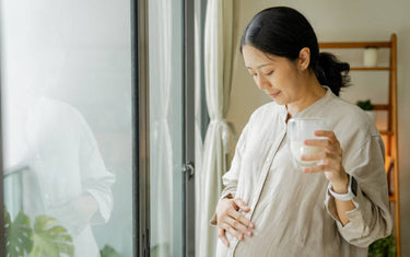 Pregnant woman holding her belly with both hands.