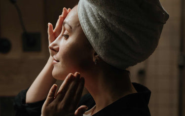 Woman with a towel on her head taking care of her skin