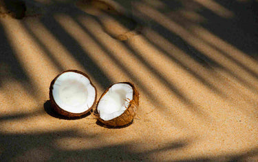 Split coconut on a beach.