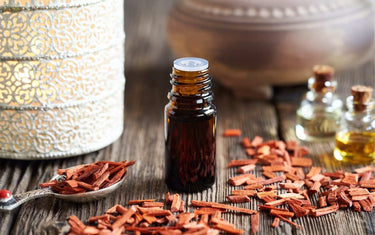 bottle of sandalwood oil with sandalwood chips around it