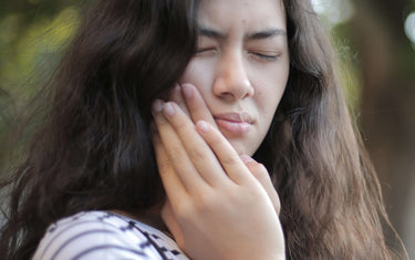 Woman holding her jaw with toothache.