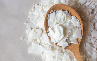 Soy Wax Flakes in a wooden spoon and around it