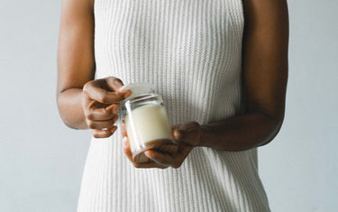 Woman applying a CLP label to the bottom of a candle