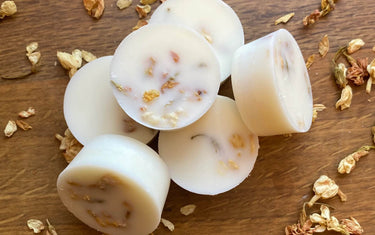 Small pile of circular wax melts with botanicals within them