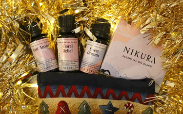 Three Nikura blends and a box surrounded by Christmas decorations.