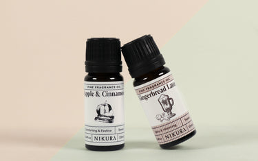 Two Nikura fragrance oils leaned up against each other