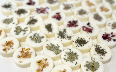 Rows of wax melts with various botanicals sprinkled on the tops of them