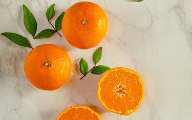 Mandarins sliced open on a marble table.