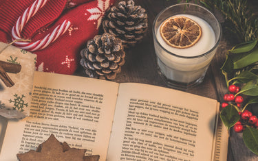 Book surrounded by Christmas ornaments.