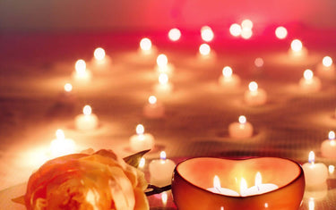 Lit candles, flower and petals arranged in a romantic way