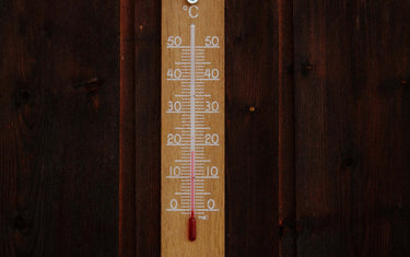 Picture of thermometer on wooden background.