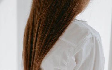 Woman with long brown hair facing away.