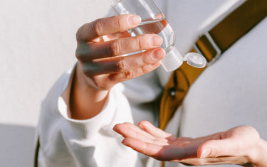 Person applies hand sanitiser from bottle onto their hand