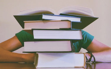 Person hiding behind a stack of books