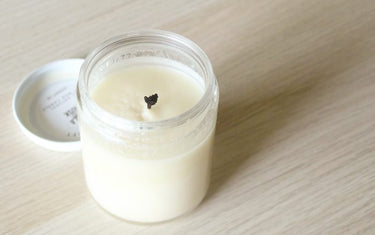 White candle on a table with a mushroom wick.