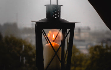 Candle lit latern being held by someone