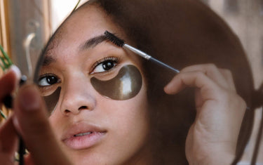 Woman applying eyebrow growth oil onto her eyebrows