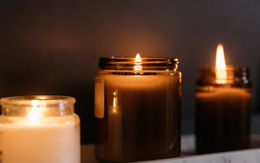 Three candles in amber glass jars.