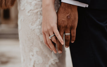 Two hands touching with wedding rings on