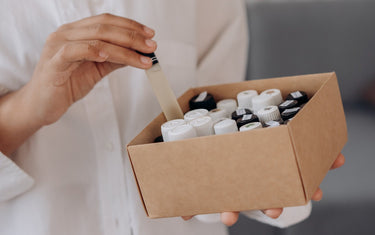 Person holding a box of fragrance oil bottles