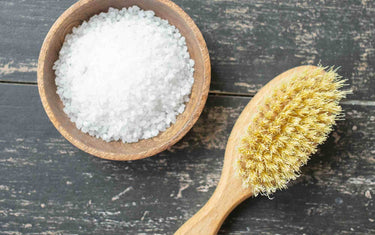 Wooden bowl of salt and a body brush