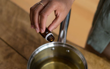 Hand dropping essential oils into a pan