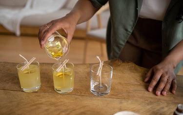 Woman pouring candle wax into three candle jars