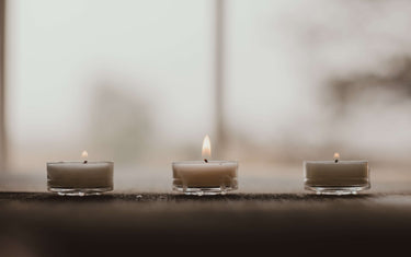 Three tea lights on a windowsill.