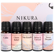 A set of five amber glass bottles with black tamper-evident lids, labeled as different essential oil blends: Calm, Citrus Relief, Four Bandits, Relax & Unwind, and Sweet Dreams. Each bottle has a dropper for easy dispensing.