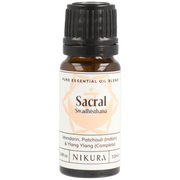 A bottle of Nikura Sacral Chakra Essential Oil Blend with a label showing the brand and product name, and a brief description of the oils contained within.