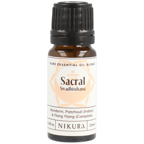 A bottle of Nikura Sacral Chakra Essential Oil Blend with a label showing the brand and product name, and a brief description of the oils contained within.